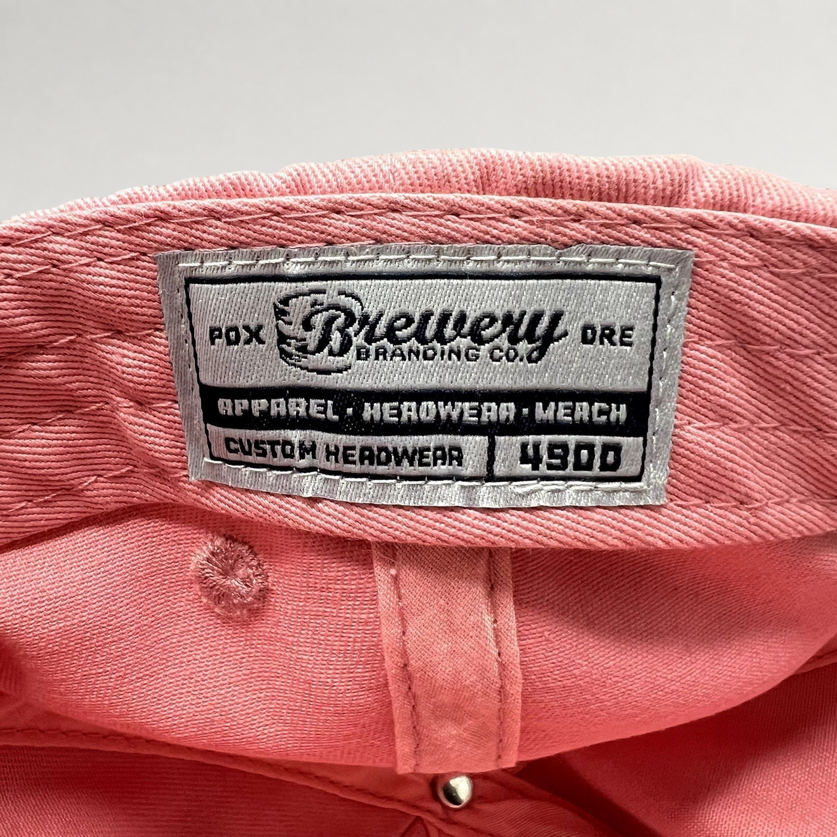 Raree Finds pink cotton strapback hat interior featuring a Brewery Branding Co woven label on the crown