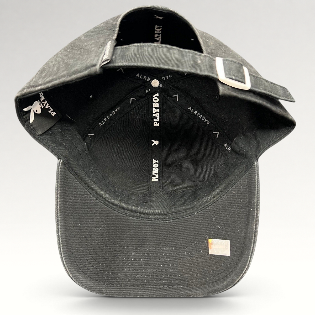 Raree Finds black Playboy strapback hat with interior Already Design Co branding and adjustable metal clasp closure