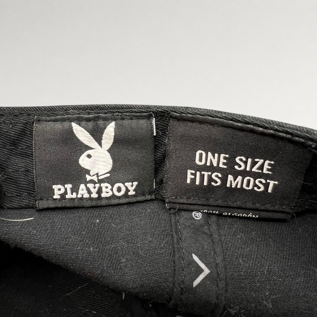Raree Finds black Playboy strapback hat interior label with bunny logo and one size fits most text