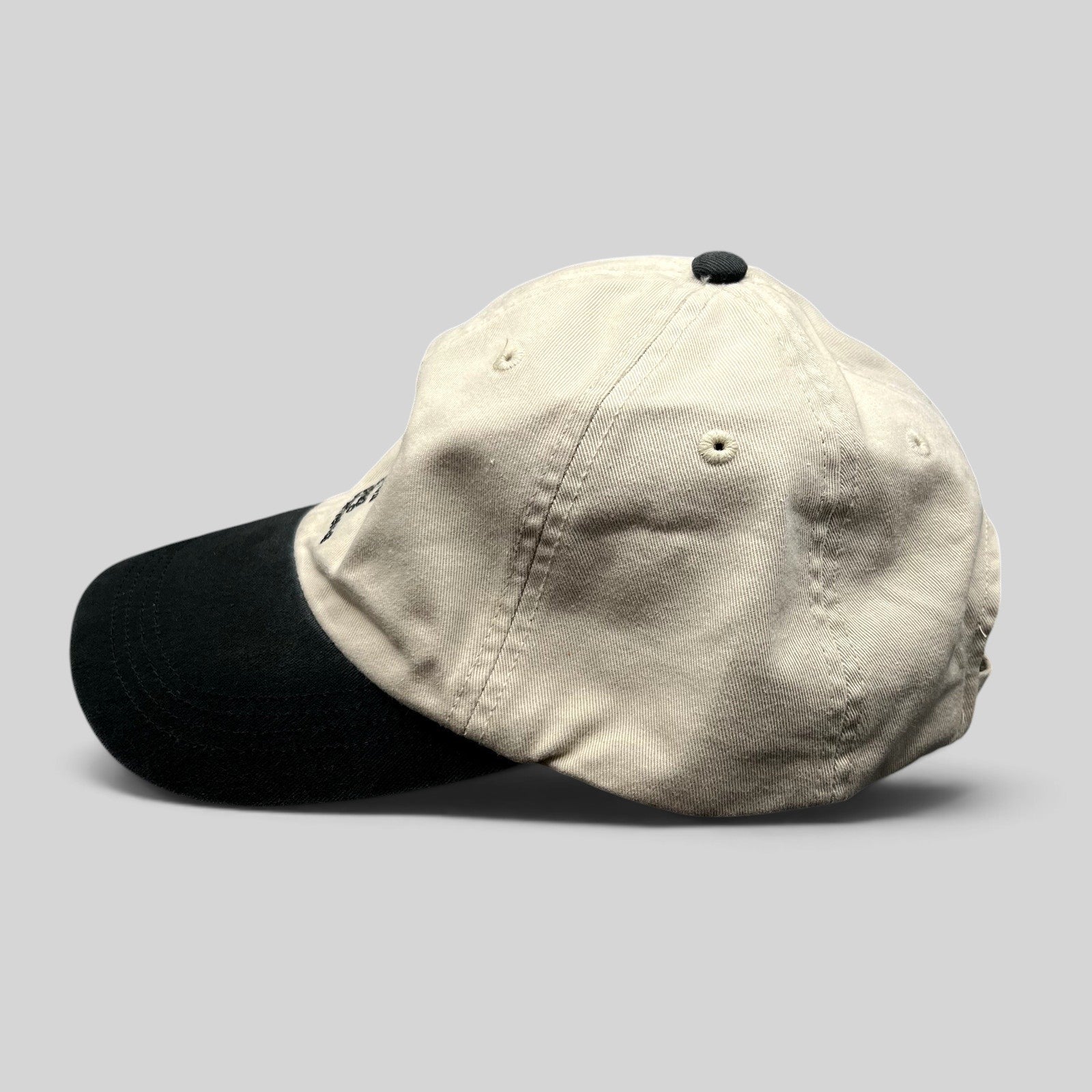 Raree Finds Porsche Driving Experience strapback hat in black and cream with embroidered logo and brass hardware.