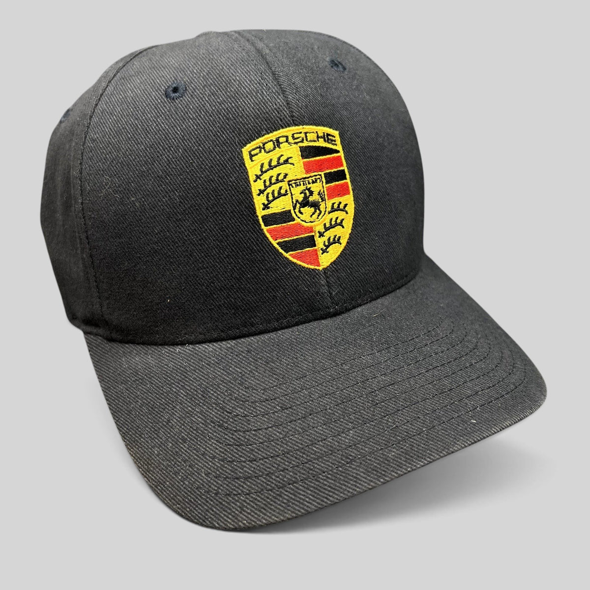 Raree Finds black Porsche Woodland Hills Flexfit cap with an embroidered Porsche crest logo on the front crown.