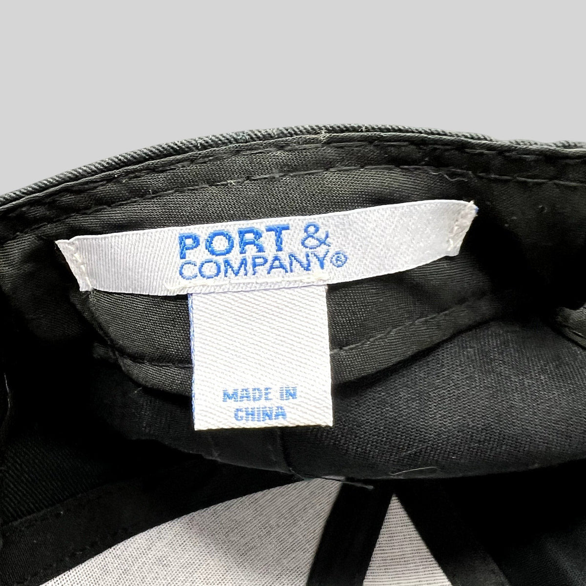 Raree Finds black strapback hat interior showing the Port & Company brand label and Made in China tag