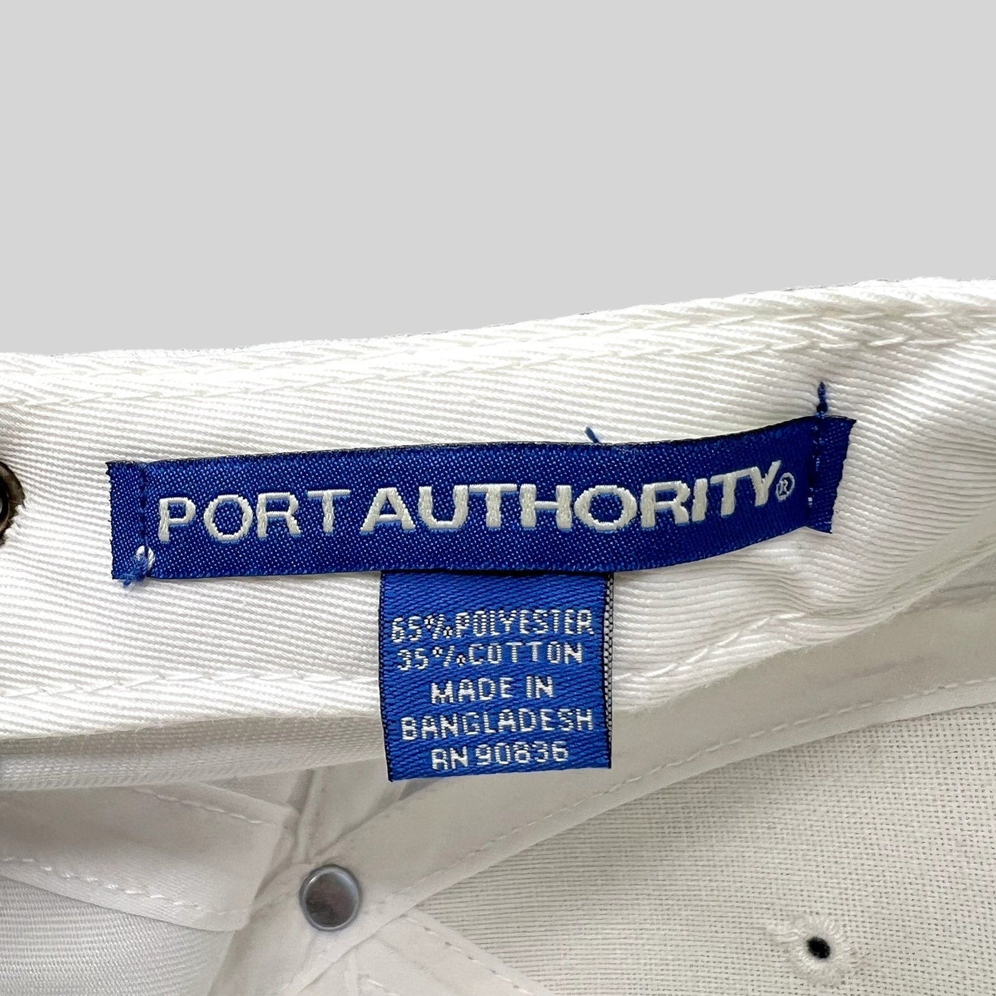 Raree Finds white Port Authority hat interior label showing 65 percent polyester and 35 percent cotton material blend