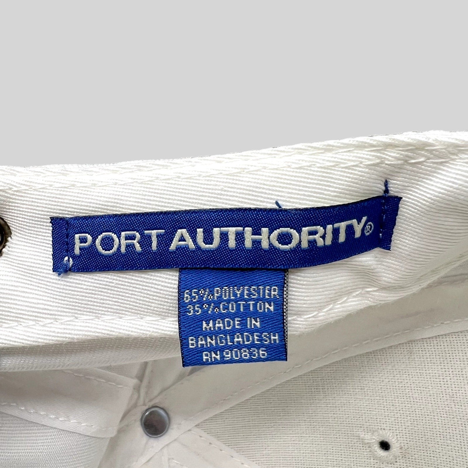 Raree Finds white Port Authority hat interior label showing 65 percent polyester and 35 percent cotton material blend