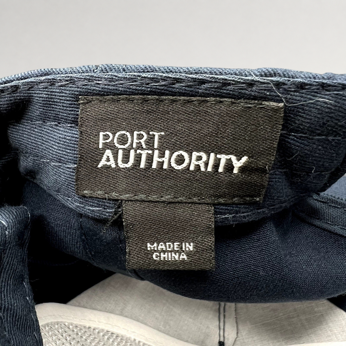 Raree Finds Port Authority navy blue snapback hat interior label showing brand name and Made in China tag