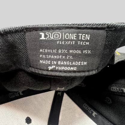 Raree Finds Postino hat interior label showing Yupoong 110 Flexfit Tech branding and material composition details.
