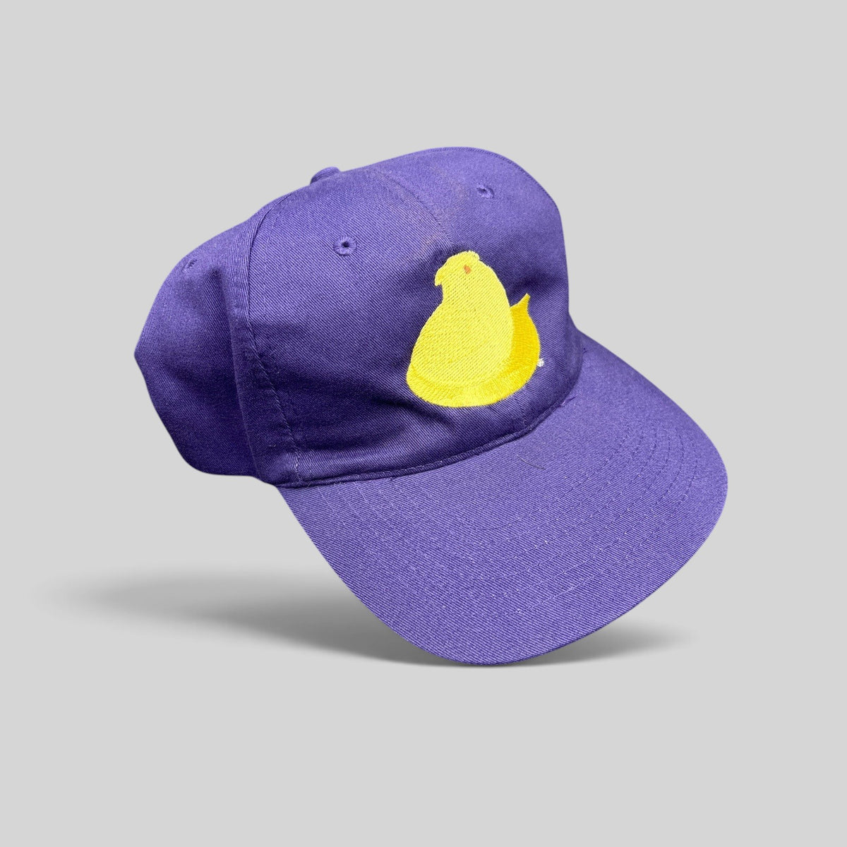 Raree Finds purple strapback cap featuring a yellow embroidered Marshmallow Peeps chick on the front panel.