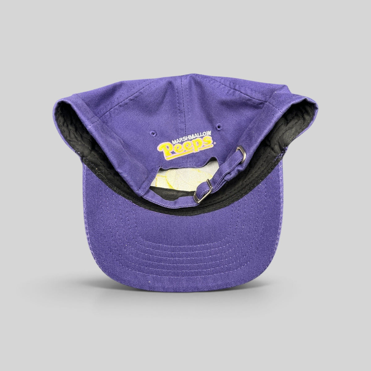 Raree Finds purple Marshmallow Peeps strapback cap showing interior brim embroidery and adjustable metal buckle