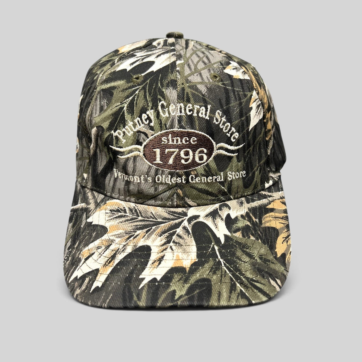 Raree Finds Putney General Store woodland camouflage strapback hat with embroidered Vermont 1796 logo on front