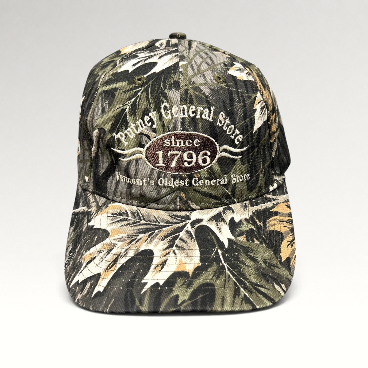 Raree Finds Putney General Store woodland camouflage strapback hat with embroidered Vermont 1796 logo on front