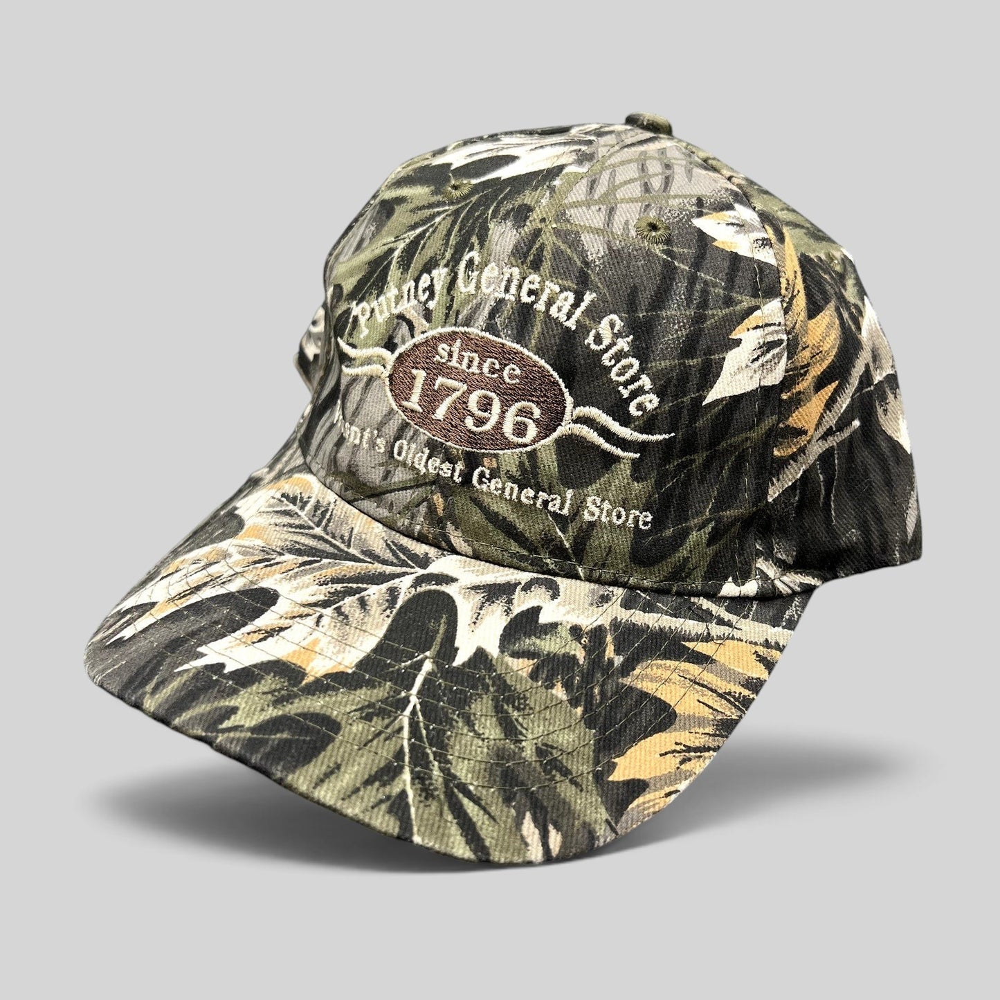Raree Finds Putney General Store woodland camo strapback hat with embroidered 1796 Vermont logo on structured crown