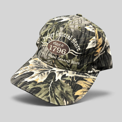 Raree Finds Putney General Store woodland camo strapback hat with embroidered 1796 Vermont logo on structured crown
