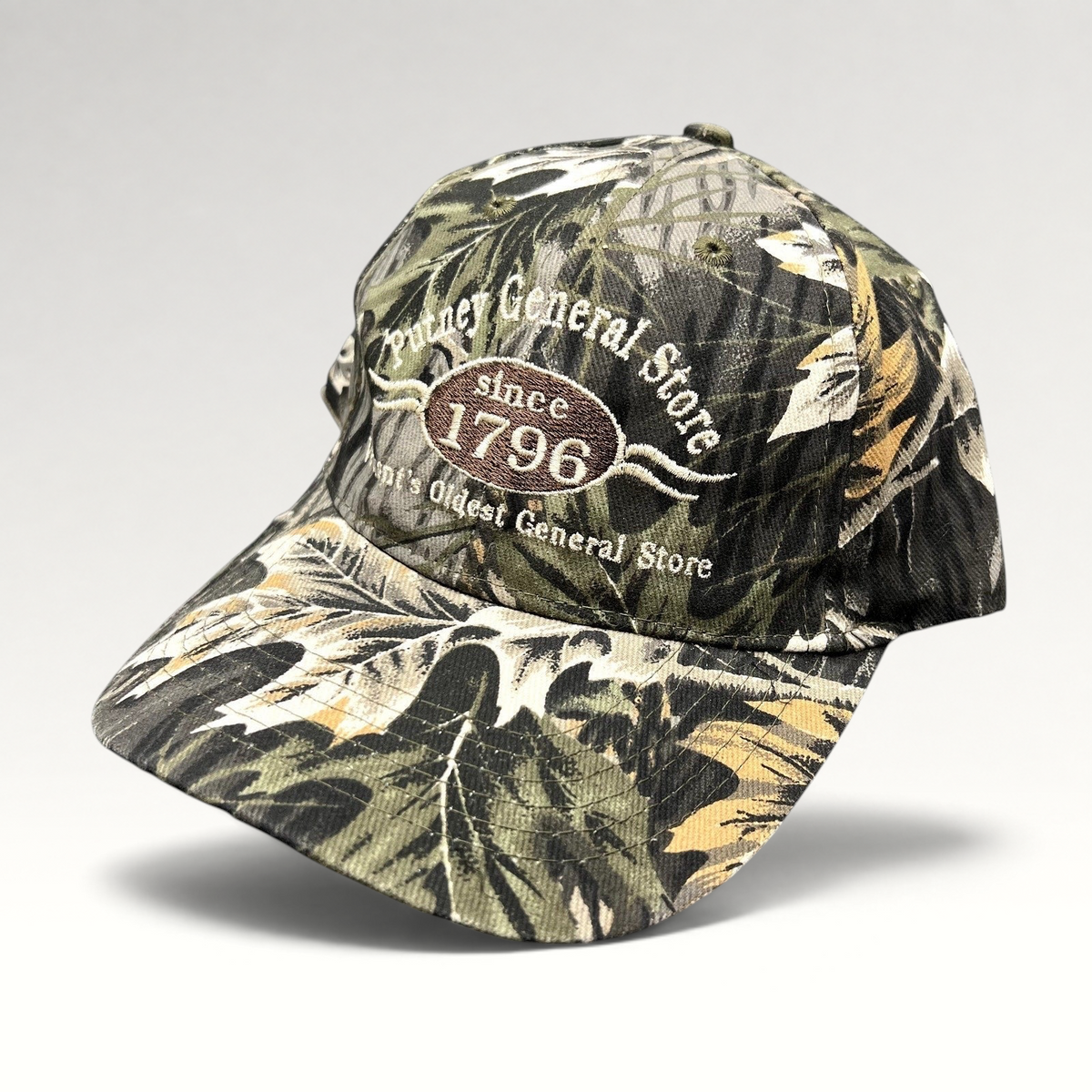 Raree Finds Putney General Store woodland camo strapback hat with embroidered 1796 Vermont logo on structured crown