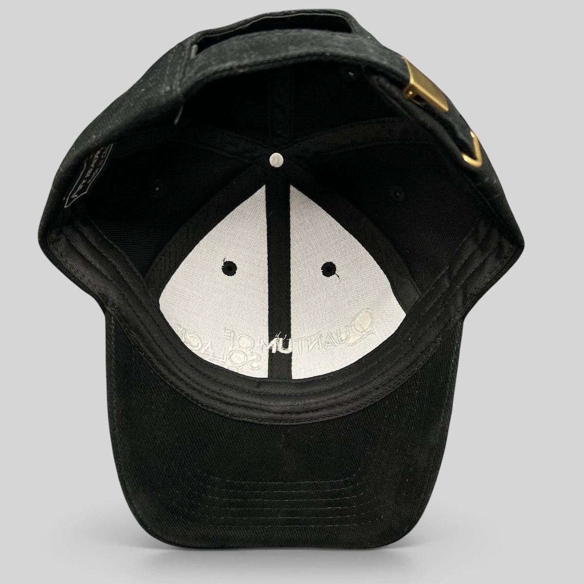 Raree Finds black Quantum of Solace 007 strapback hat showing the interior lining and brass buckle closure.