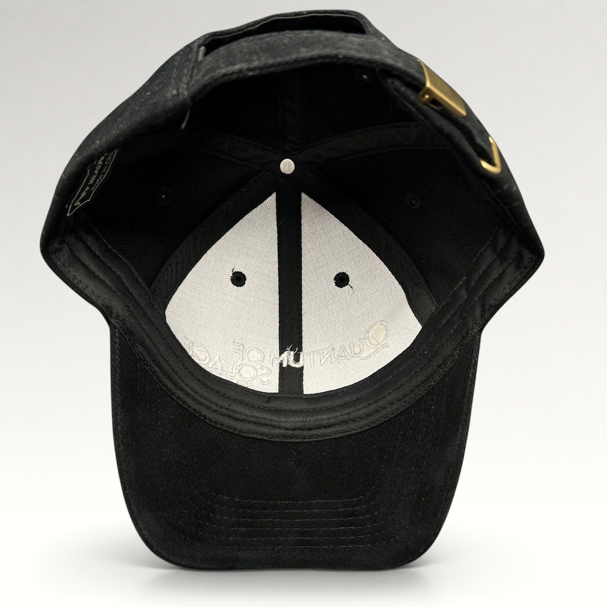 Raree Finds black Quantum of Solace 007 strapback hat showing the interior lining and brass buckle closure.