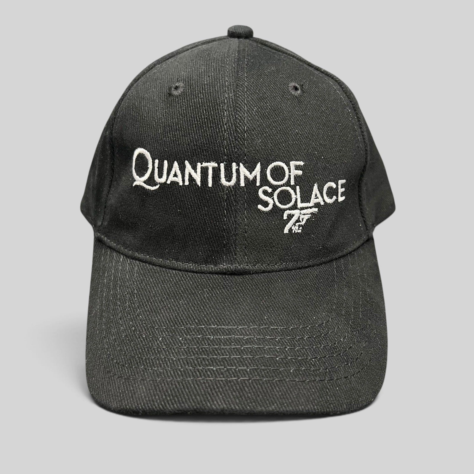 Raree Finds black Quantum of Solace strapback hat with white 007 gun logo embroidery and curved bill
