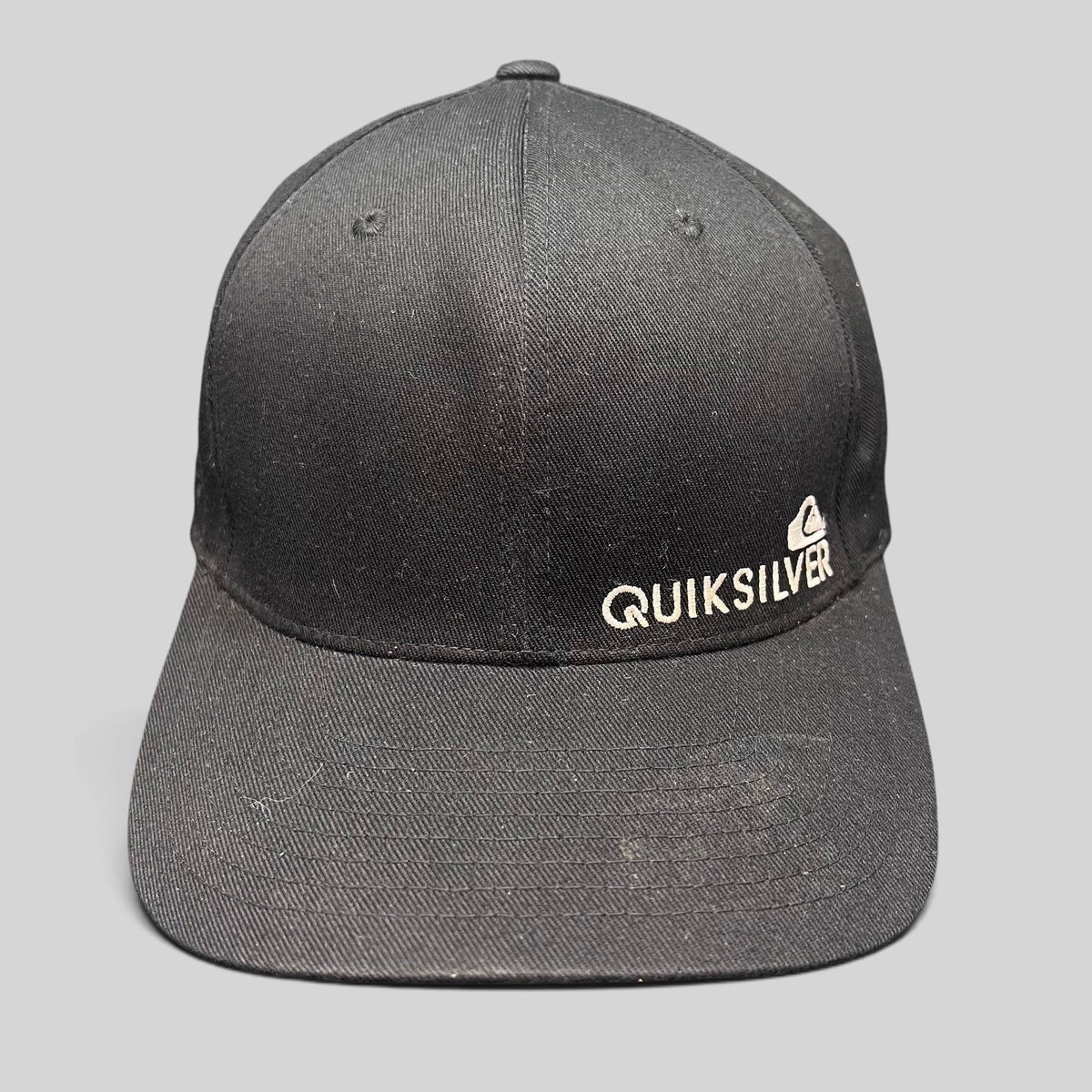 Raree Finds black Quiksilver Flexfit cap with white embroidered mountain and wave logo on a structured crown