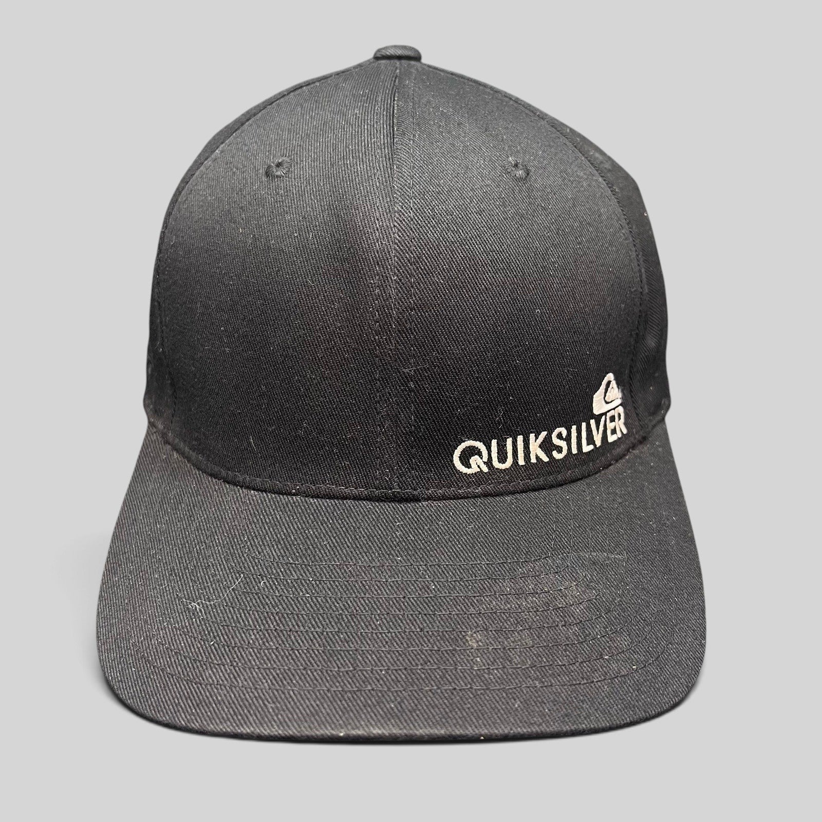 Raree Finds black Quiksilver Flexfit cap with white embroidered mountain and wave logo on a structured crown