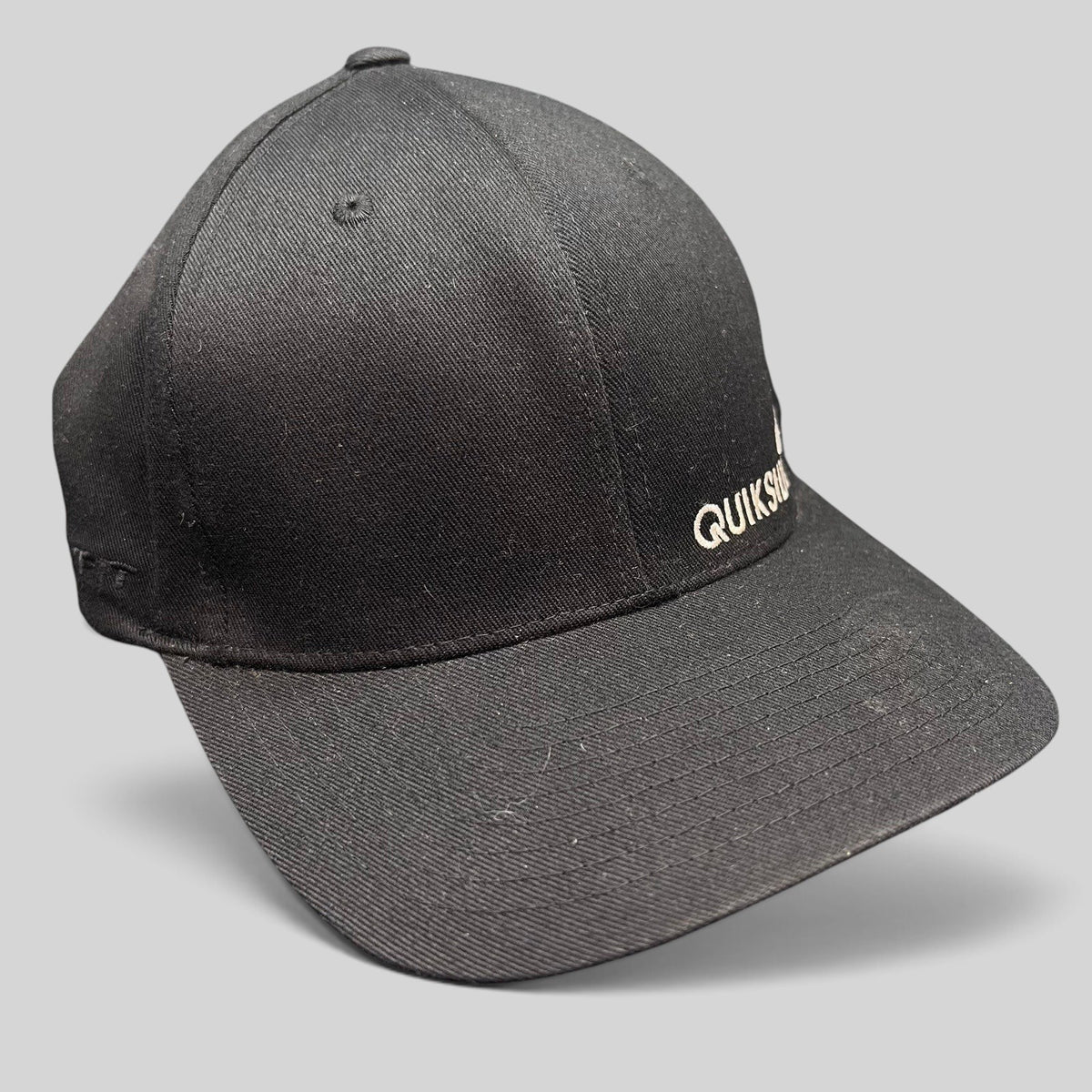 Raree Finds black Quiksilver Flexfit cap with white embroidered logo and structured curved bill for surf and skate wear.