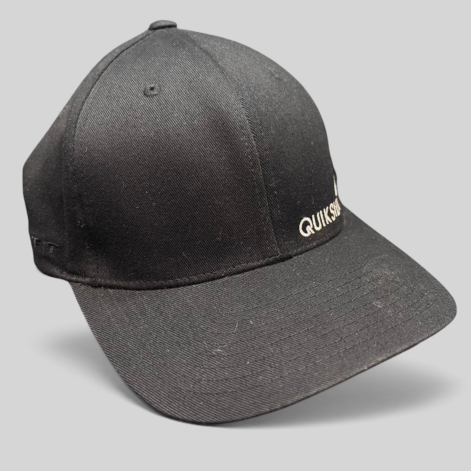 Raree Finds black Quiksilver Flexfit cap with white embroidered logo and structured curved bill for surf and skate wear.