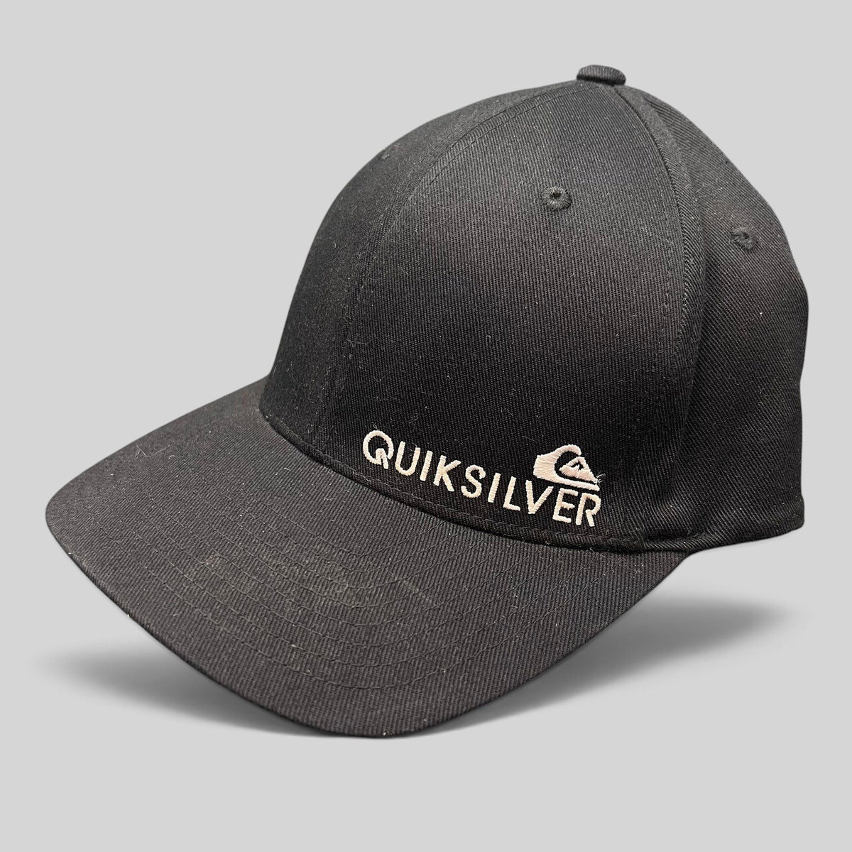 Raree Finds black Quiksilver Flexfit cap with white embroidered mountain and wave logo on a structured curved bill