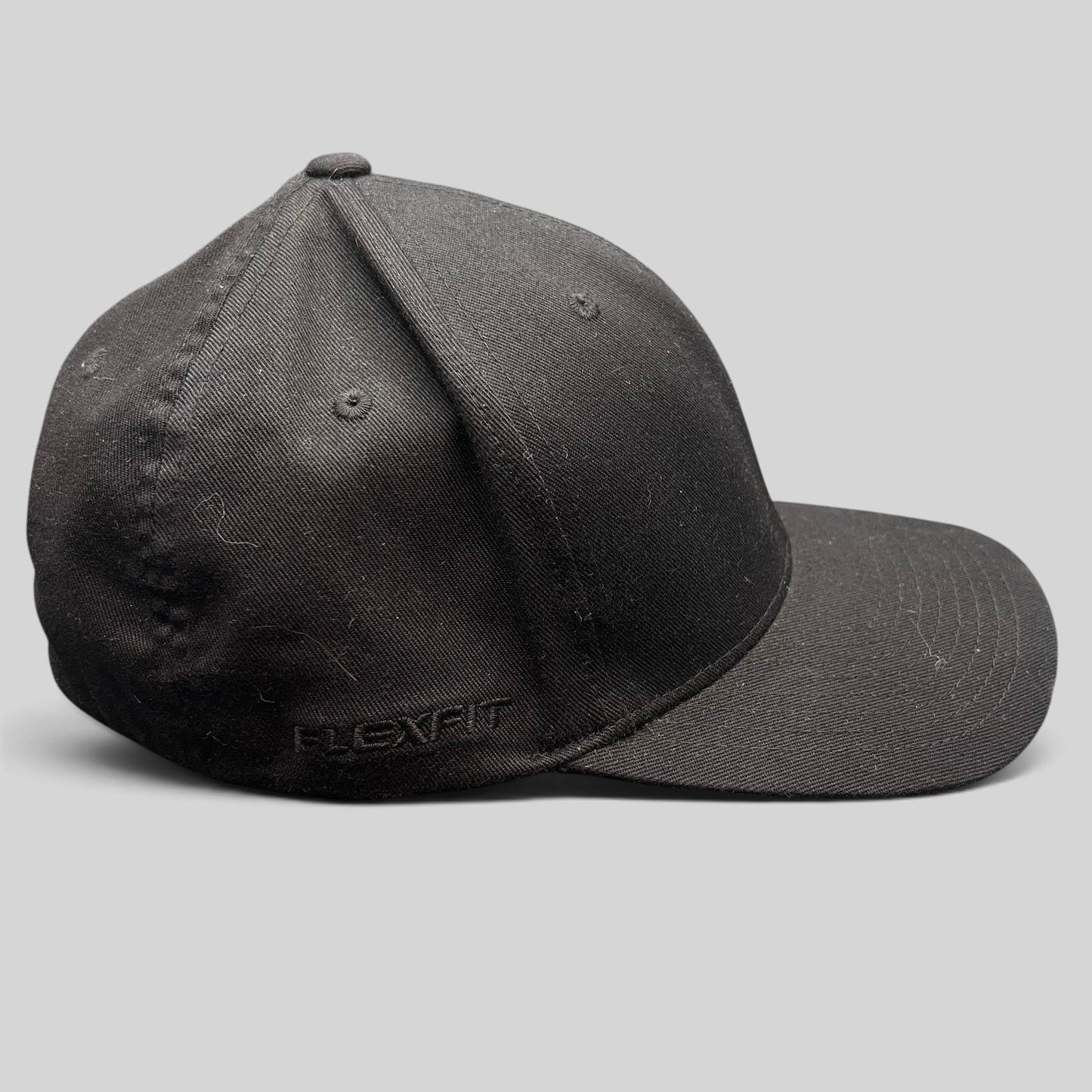 Raree Finds black Quiksilver Flexfit cap with a structured crown and curved bill, side view.