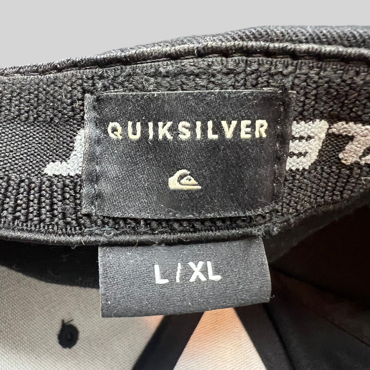 Raree Finds Quiksilver black Flexfit cap interior label showing L/XL size and brand logo