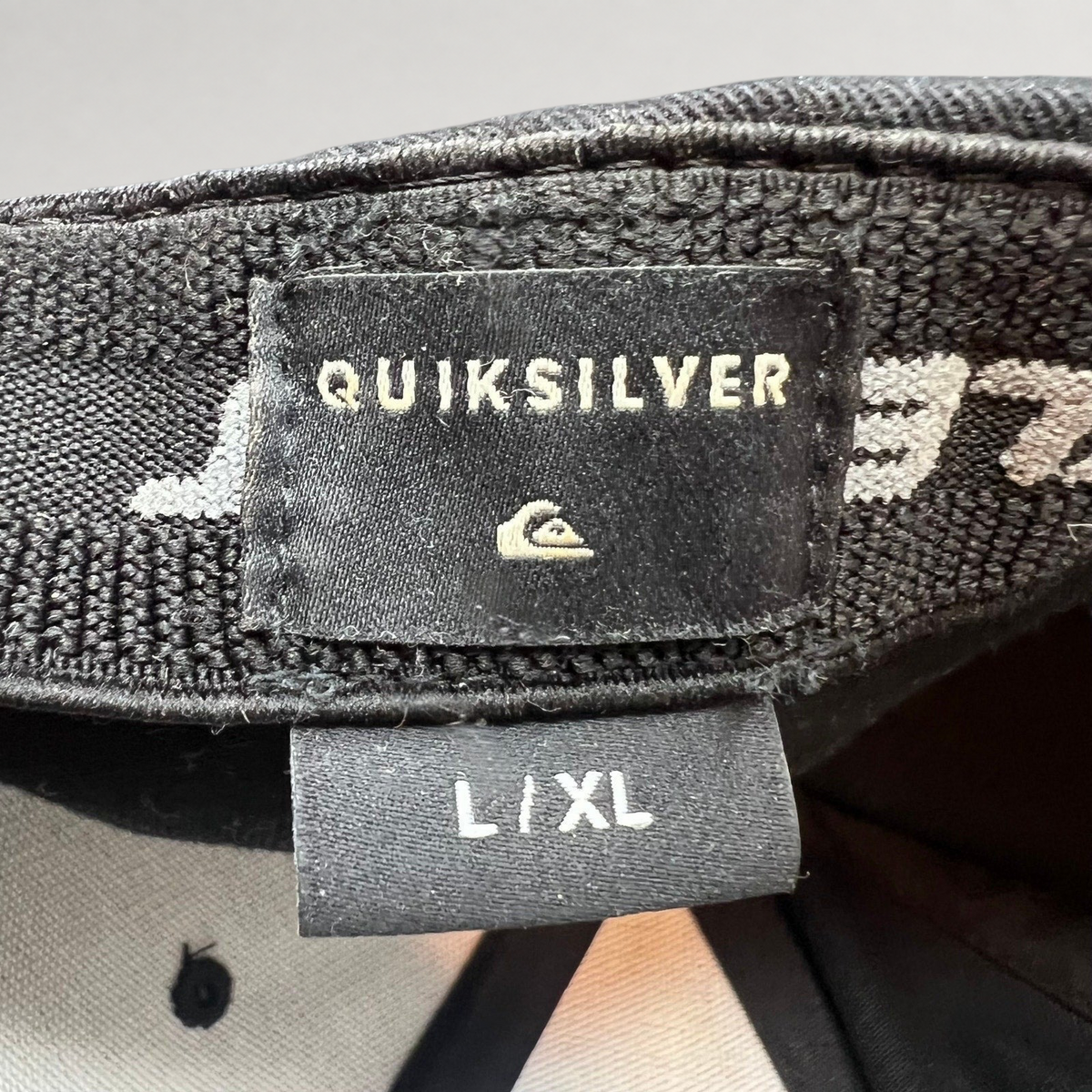 Raree Finds Quiksilver black Flexfit cap interior label showing L/XL size and brand logo