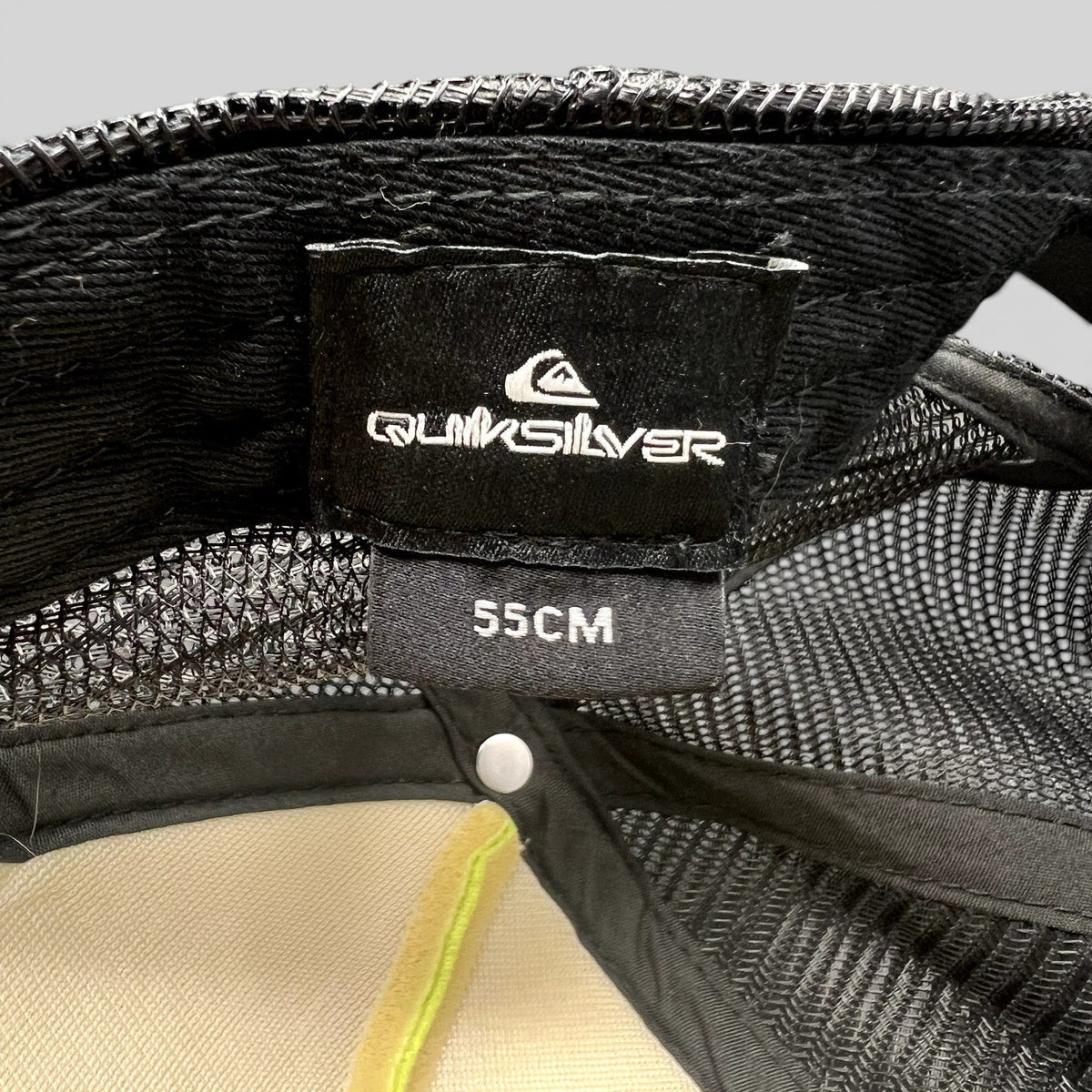 Raree Finds Quiksilver trucker hat interior label showing brand logo and 55cm size tag with black mesh lining