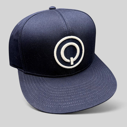 Raree Finds navy blue Quixote Studios snapback hat with a white embroidered circular Q logo and flat brim