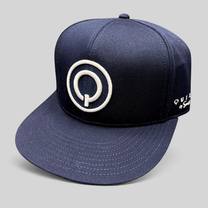 Raree Finds navy blue Quixote Studios snapback hat with a white embroidered circular Q logo and flat brim