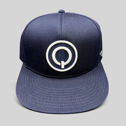 Raree Finds navy blue Quixote Studios snapback hat with a white embroidered circular Q logo and flat brim