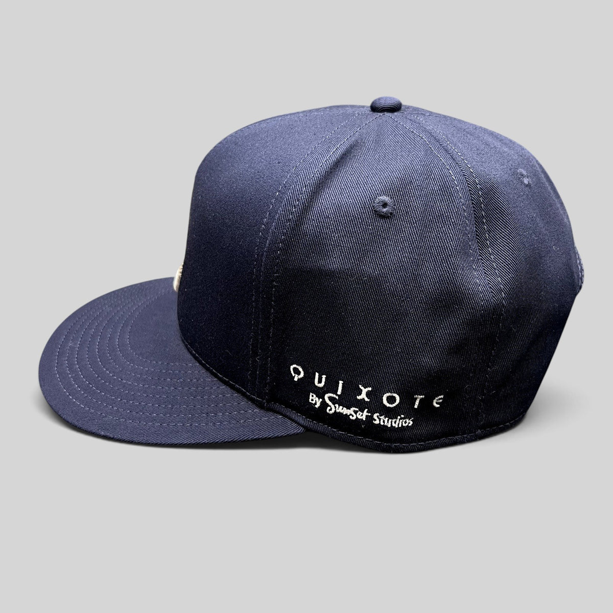 Raree Finds navy blue Quixote by Sunset Studios snapback hat with white embroidered side logo and flat brim
