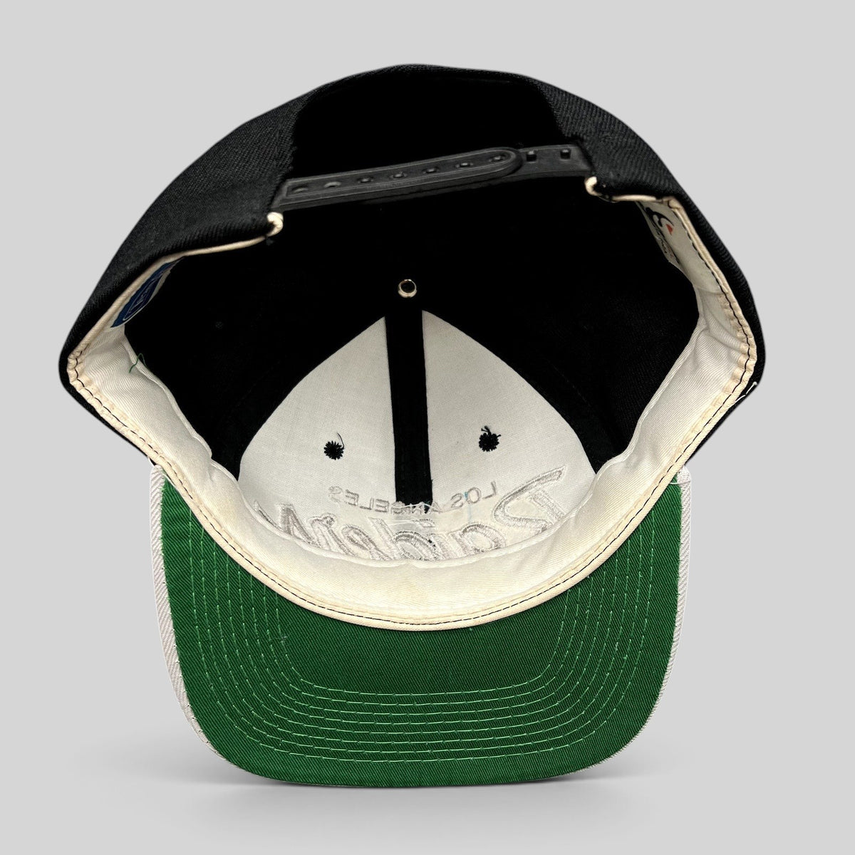 Raree Finds vintage Sports Specialties Los Angeles Raiders snapback hat showing the green undervisor and interior