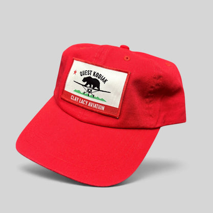 Raree Finds bright red cotton strapback hat with a woven Quest Kodiak and Clay Lacy Aviation aircraft patch