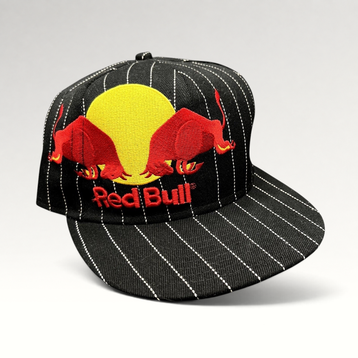 Raree Finds black and white pinstripe New Era 59FIFTY fitted hat with embroidered Red Bull logo and flat brim.