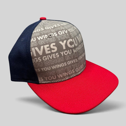 Raree Finds New Era Red Bull snapback hat with grey Gives You Wings text pattern, navy panels, and a red brim.