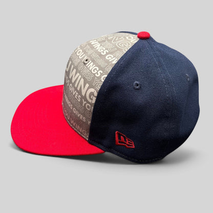 Raree Finds New Era Red Bull snapback hat with grey slogan print, navy side panels, and a bright red brim.