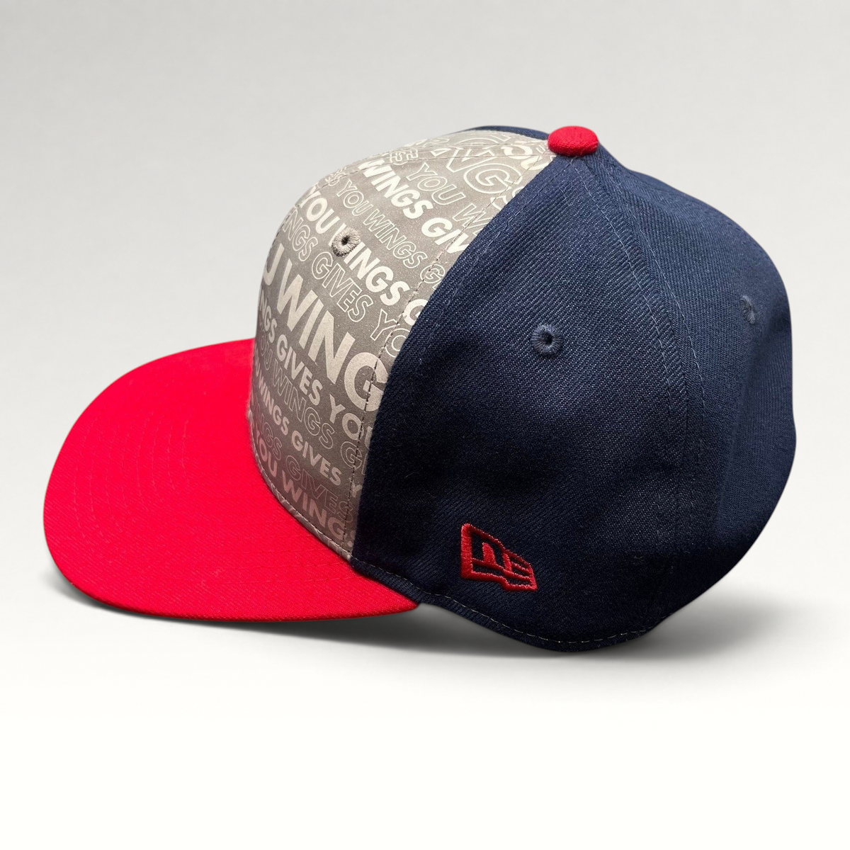Raree Finds New Era Red Bull snapback hat with grey slogan print, navy side panels, and a bright red brim.