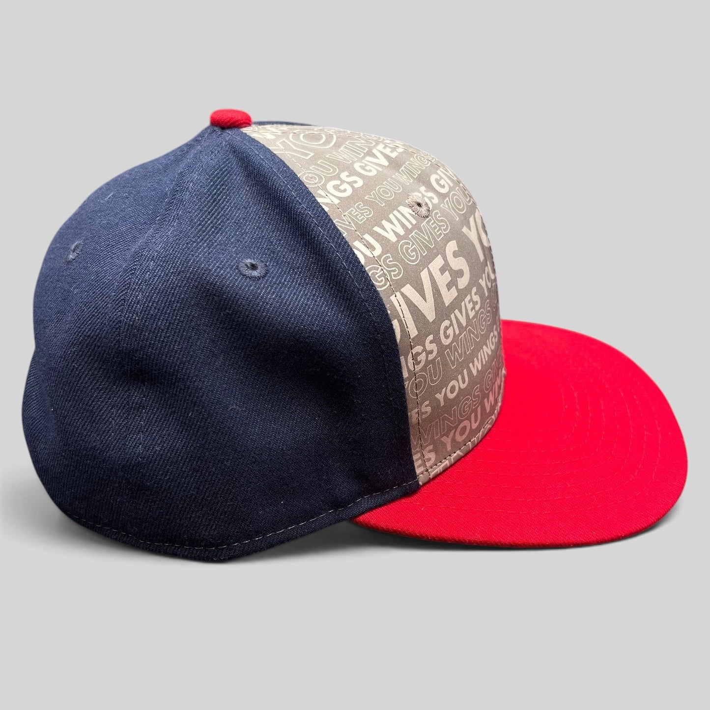 Raree Finds New Era Red Bull snapback hat with grey slogan print, navy side panels, and a bright red brim.