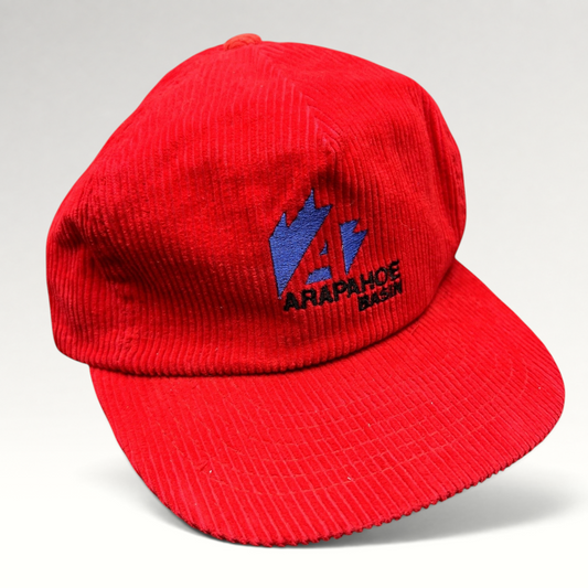 Raree Finds vintage red corduroy Arapahoe Basin ski hat with embroidered blue mountain logo and structured crown.
