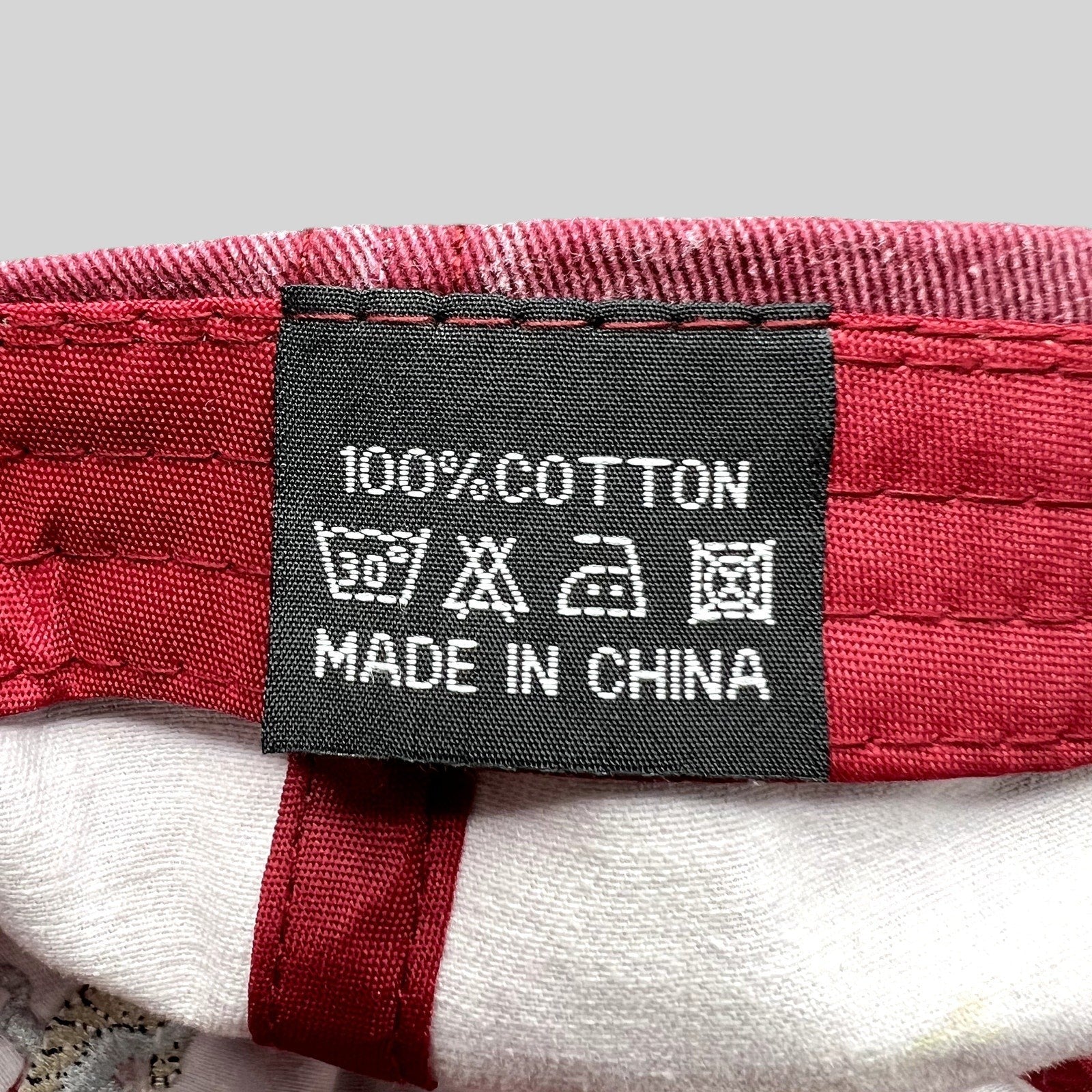 Raree Finds vintage red cotton hat interior care label showing 100% cotton material and laundry instructions