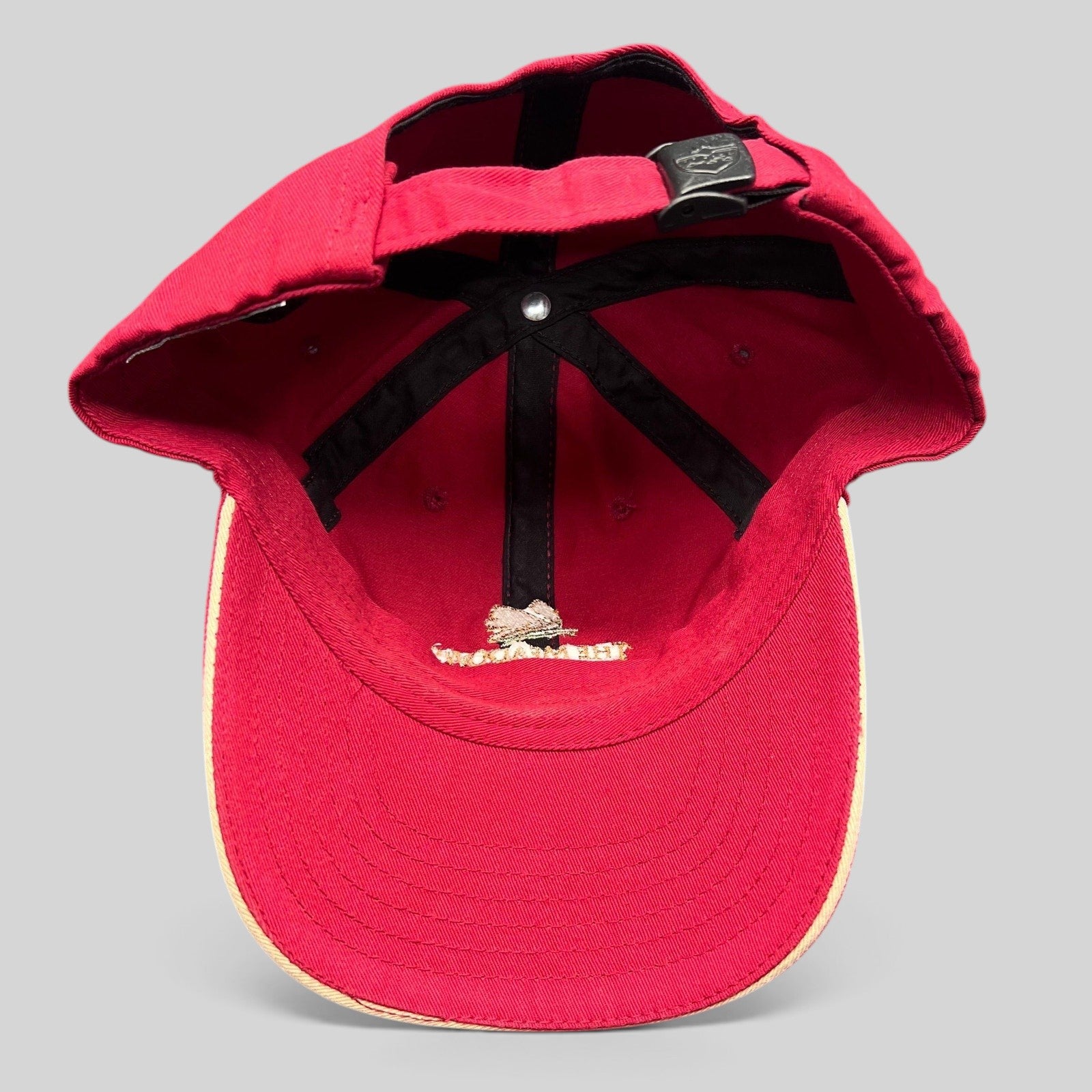 Raree Finds red cotton strapback golf cap from The Meadows Del Mar, showing the interior six-panel construction.