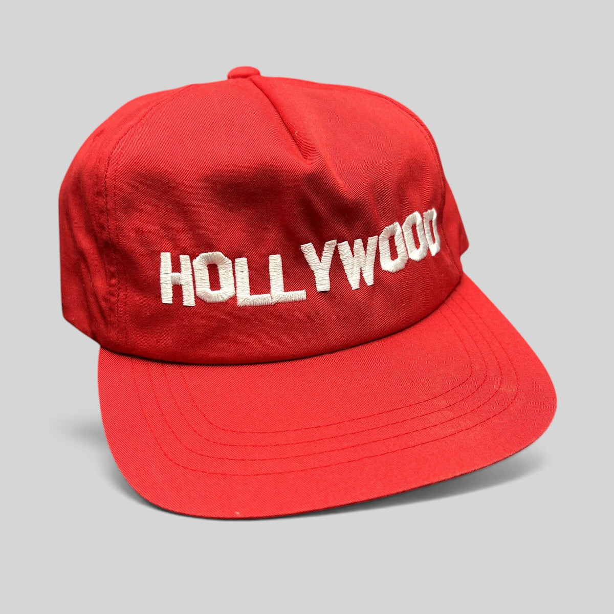 Raree Finds retro red Yupoong snapback hat with white embroidered HOLLYWOOD lettering and a structured flat brim.