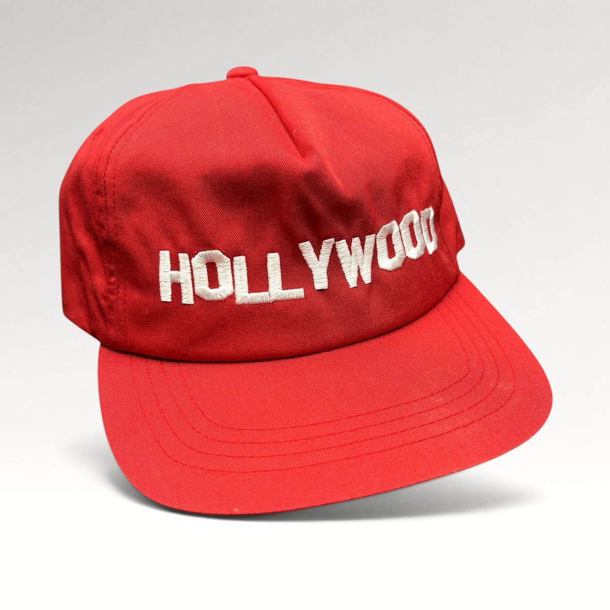 Raree Finds retro red Yupoong snapback hat with white embroidered HOLLYWOOD lettering and a structured flat brim.