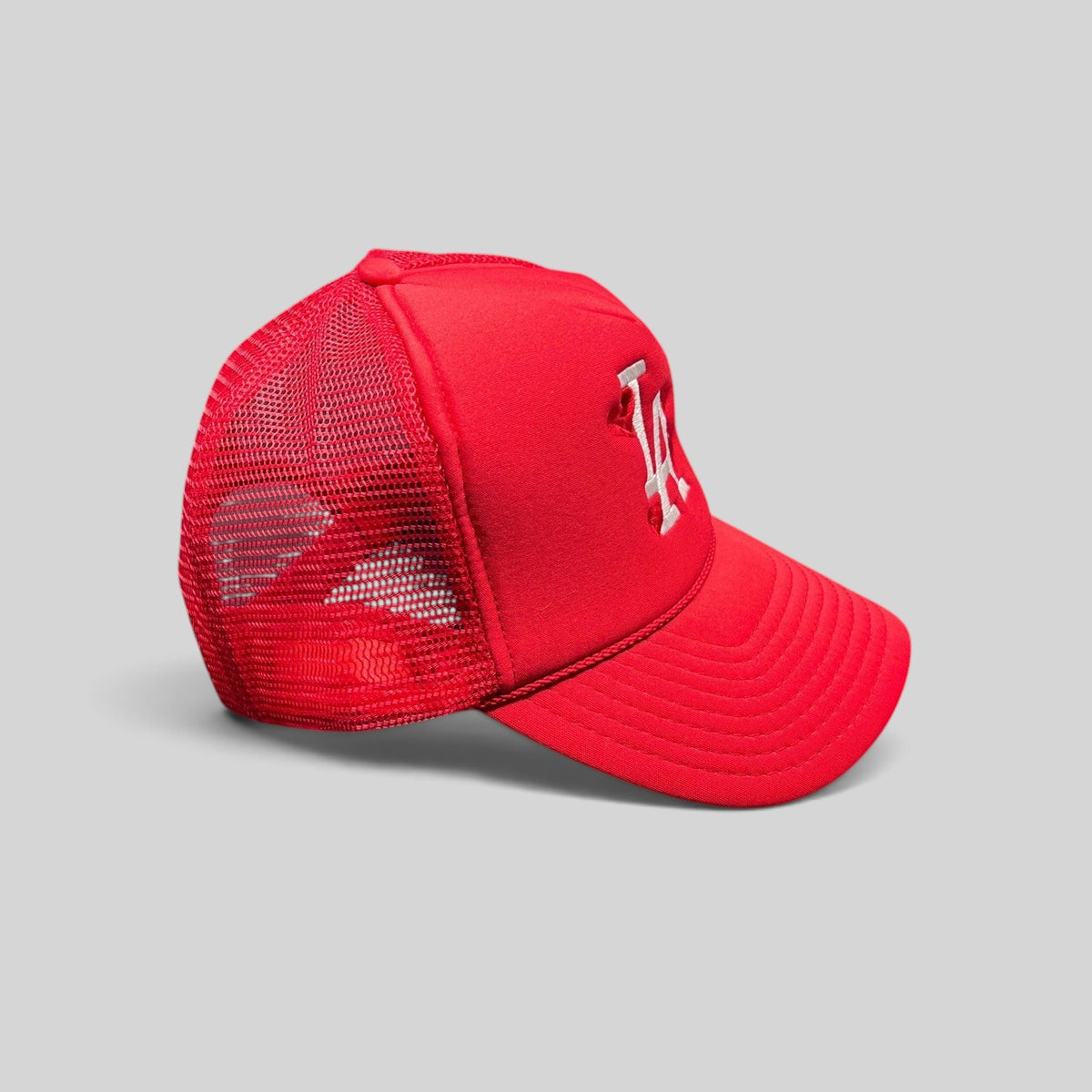 Raree Finds red Nissin Cap trucker hat with white embroidered LA logo and heart motifs on a foam front mesh back