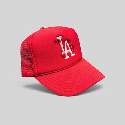 Raree Finds red Nissin Cap trucker hat with white embroidered LA logo and heart details on a foam front mesh back.