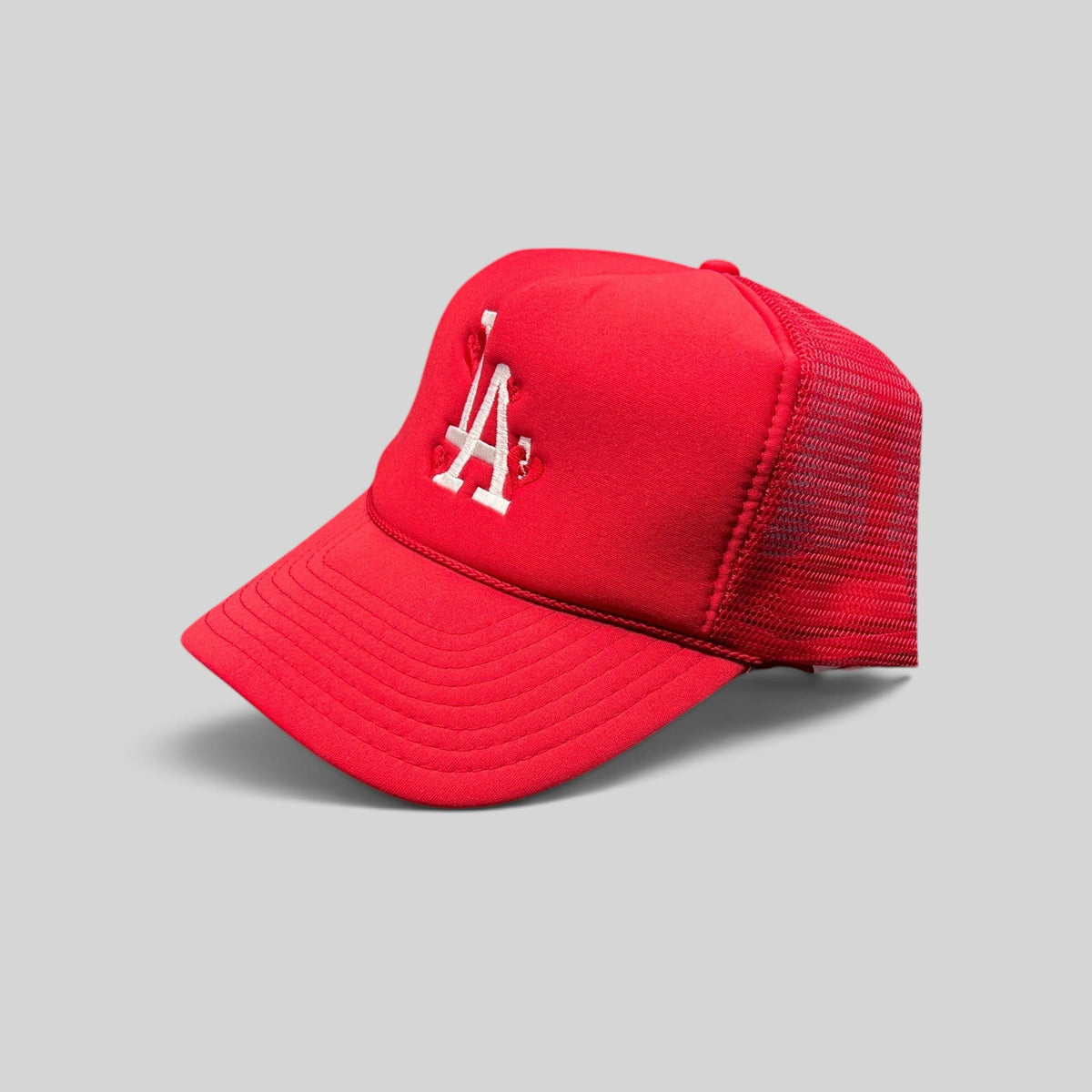 Raree Finds red Nissin Cap trucker hat with white embroidered LA logo and heart detail on a foam front mesh back