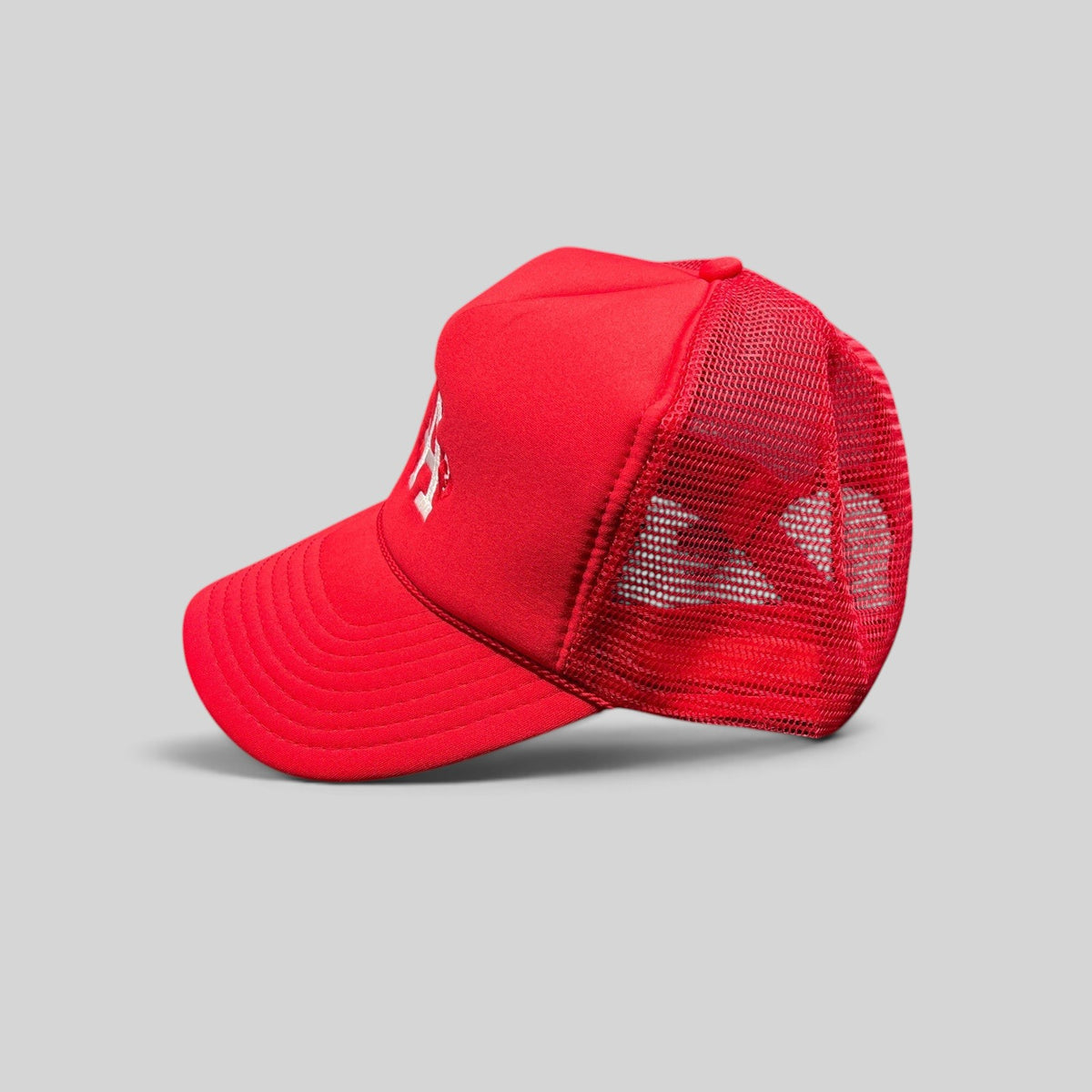 Raree Finds red Nissin Cap trucker hat with foam front, mesh back, and embroidered LA heart logo on a curved bill.