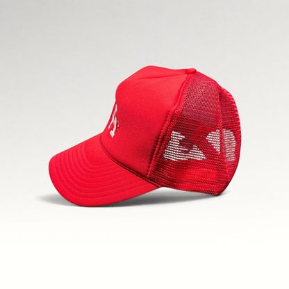 Raree Finds red Nissin Cap trucker hat with foam front, mesh back, and embroidered LA heart logo on a curved bill.